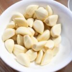 Immagine di aglio piantato con fase lunare visibile, simbolo della corretta semina a dicembre.